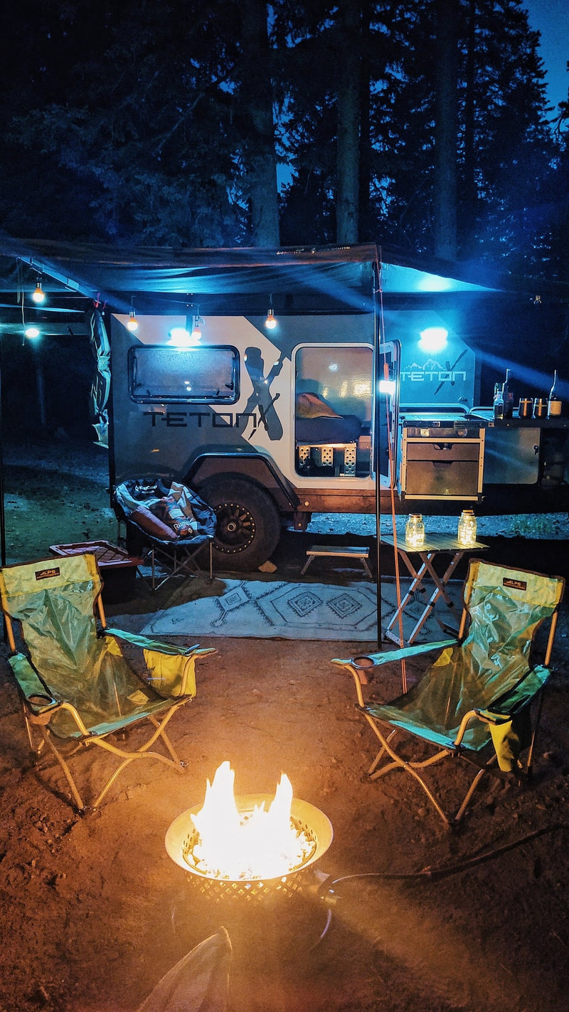  and control panel for comfortable travel.|An RV rental towing an off-road adventure trailer is parked at a scenic desert campsite with layered rock cliffs.|Silver SUV towing a Teton C camper trailer — photo 11