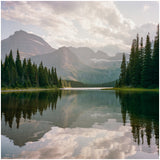 Experience serene nature: a tranquil mountain lake surrounded by dense forests & majestic peaks, ideal for an RV rental trip.