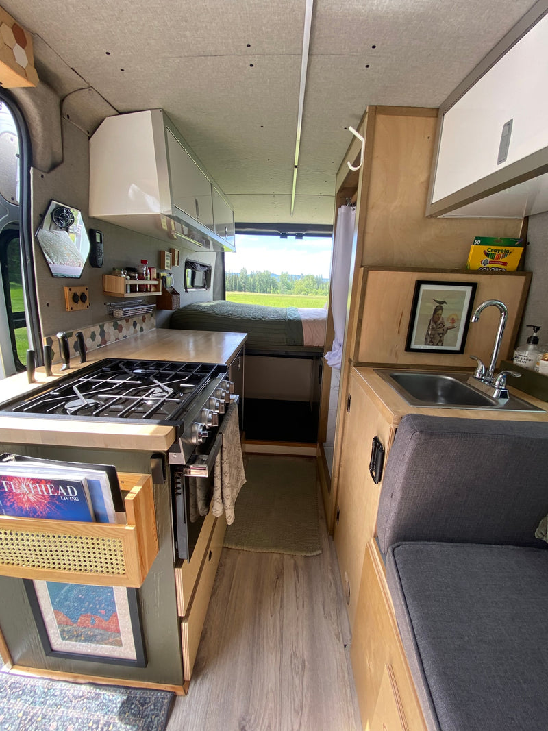  and blue sky from the open back doors.|Compact rv rental interior featuring a shower — photo 14