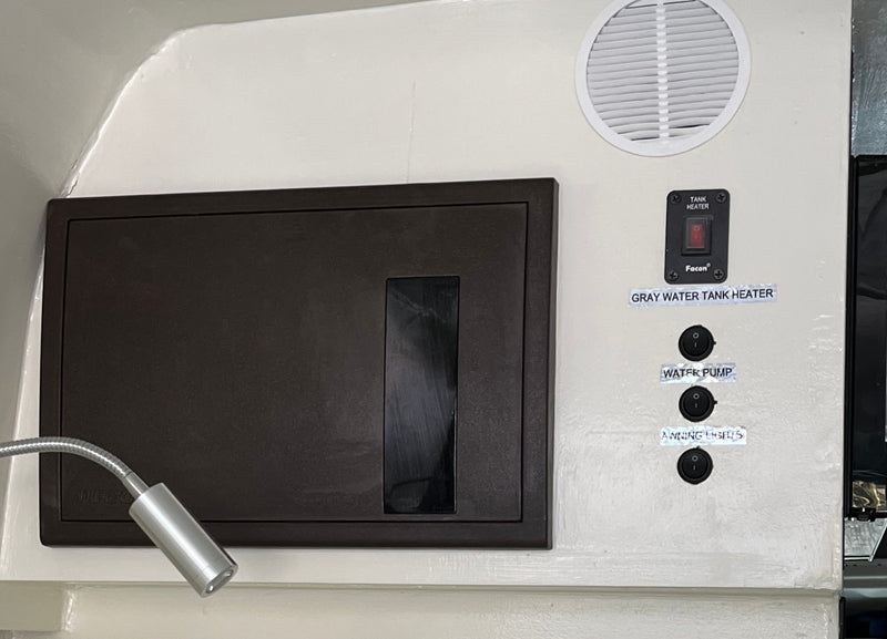 Essential RV rental control panel: Tank heater, water pump, awning lights switches, plus a flexible reading light. — photo 12