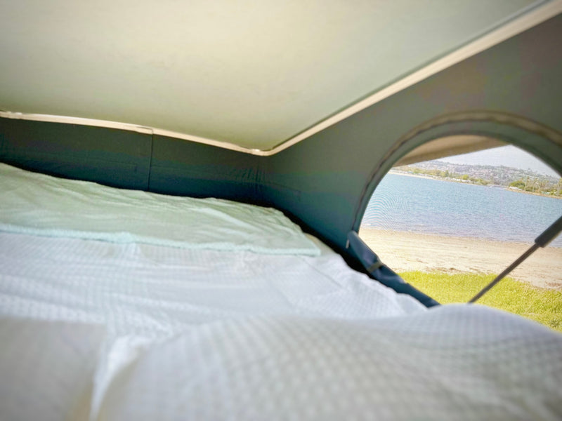  showcasing its pop-top roof and mesh screen door.|RV rental interior: Man interacts with a compact camper van kitchen featuring a sink — photo 8