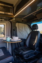 Explore this RV rental's well-equipped interior: a GE microwave, dining area with full place settings, and comfortable seating.