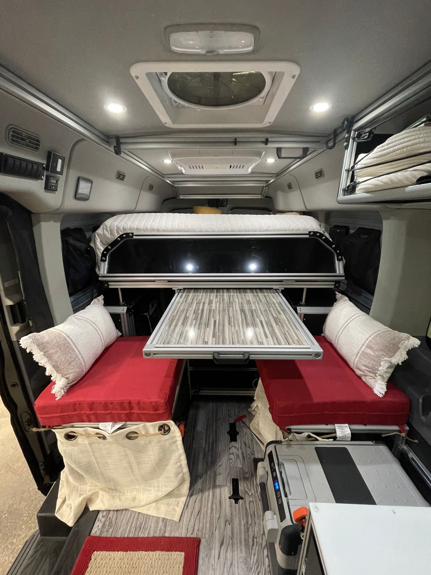 RV rental interior: clever design with bed, pull-out table, seating, and ample storage for trips. — photo 11