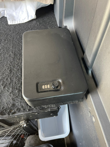 Secure gear in your rv rental: a compact safe with a combination lock sits in the vehicle's rear storage area.