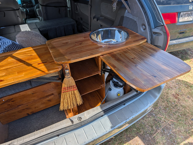  and table. Sunny tropical view outside for road trips.|Cozy RV rental interior: custom van conversion with a gray convertible bed — photo 4