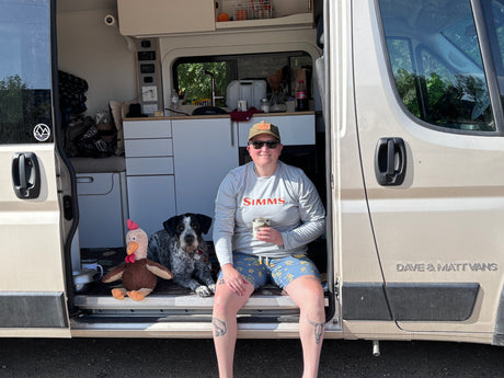 Enjoying a pet-friendly rv rental adventure! A person, dog, & chicken toy relax inside a custom van.
