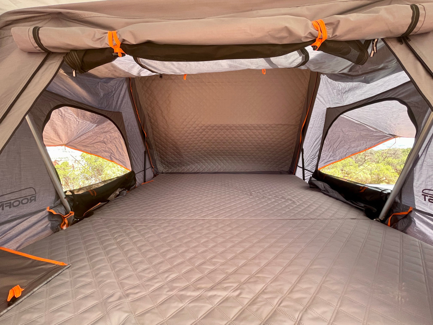 Cozy rooftop tent interior with a quilted mattress, offering comfort for your RV rental camping adventure.