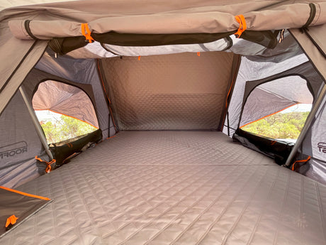 Cozy rooftop tent interior with a quilted mattress, offering comfort for your RV rental camping adventure.