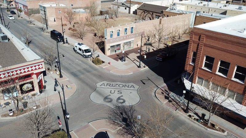Aerial view of Winslow, AZ's Route 66 intersection, featuring an RV rental and historic architecture. — photo 16