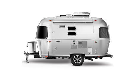 A modern, silver recreational travel trailer, often sought for rv rental, featuring distinctive oval windows and roof AC.