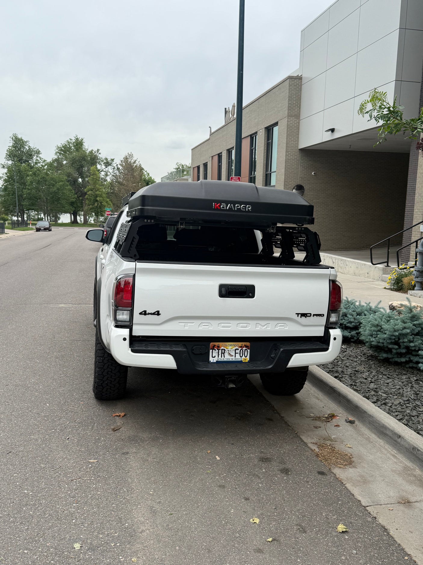 White Toyota Tacoma pickup truck, equipped with an iKamper rooftop tent, a great RV rental alternative for outdoor adventures.