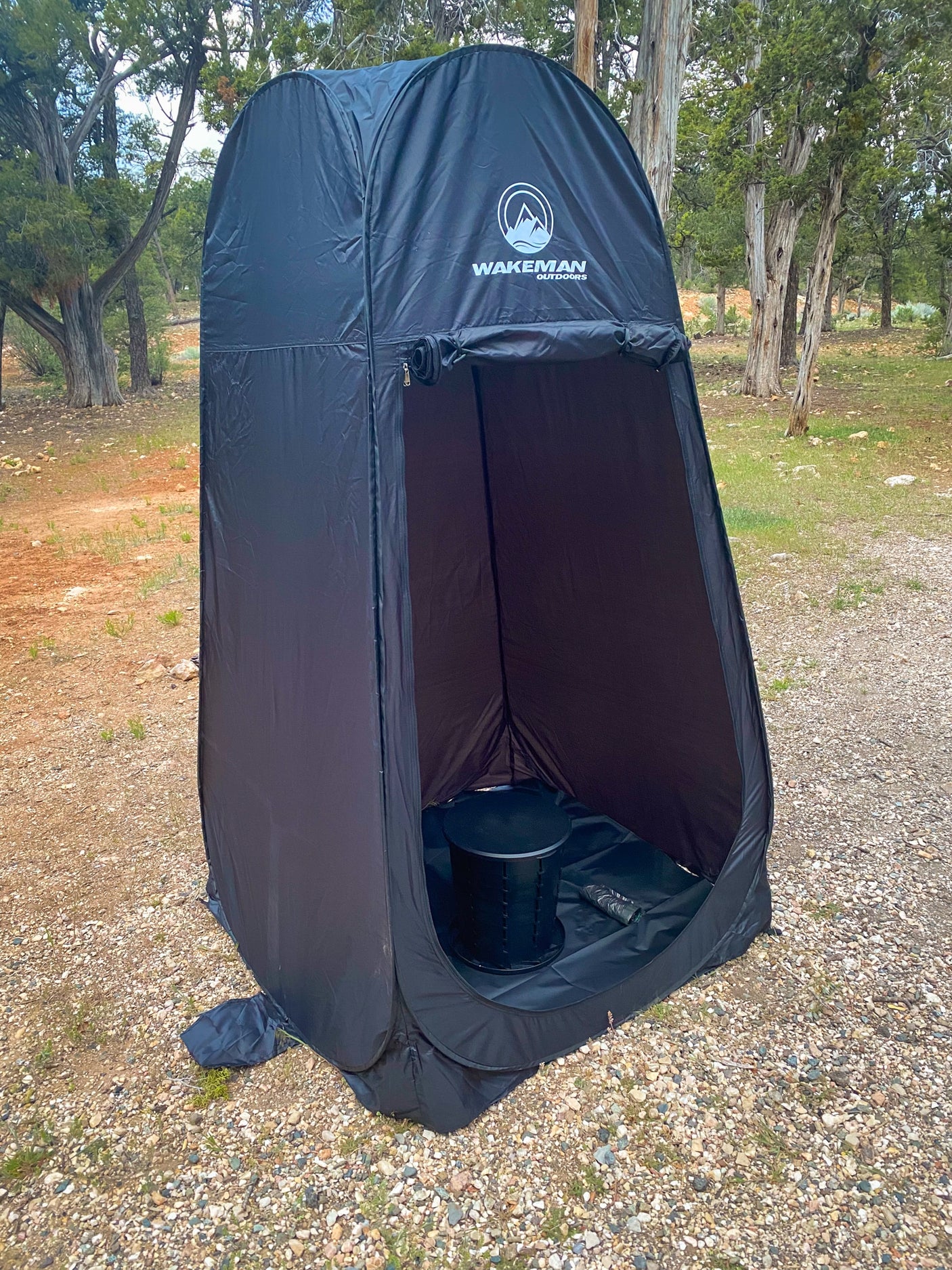 Black pop-up privacy tent with a camping toilet inside, ideal for RV rental trips, offering outdoor convenience for campers.