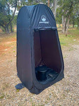 Black pop-up privacy tent with a camping toilet inside, ideal for RV rental trips, offering outdoor convenience for campers.
