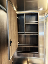 RV rental interior: open wood grain cabinet with multiple shelves and white retention bars for secure storage.