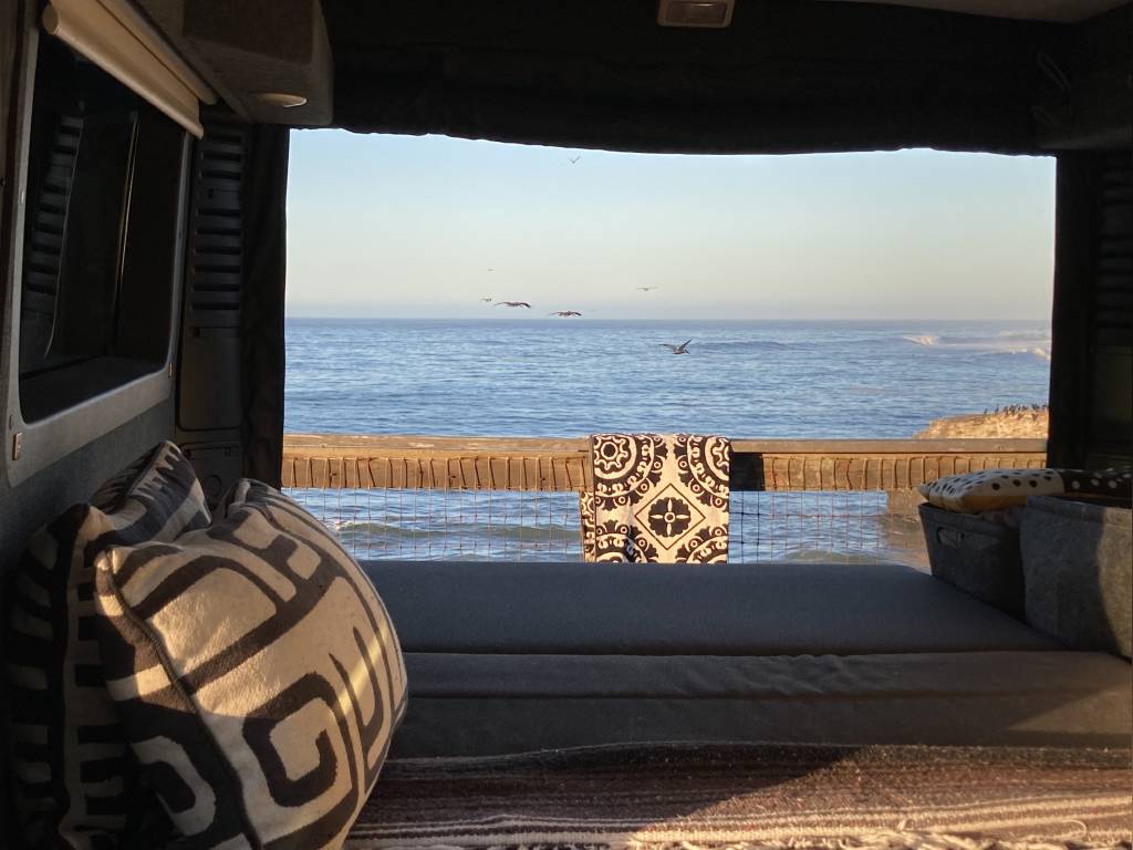  and blue mugs.|Ocean view from an RV rental: a cozy bed overlooking calm waters — photo 5