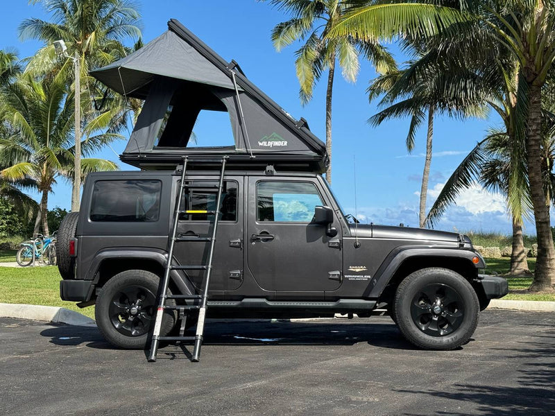 This grey Jeep Wrangler with a rooftop tent is an ideal RV rental for tropical camping adventures. — photo 14