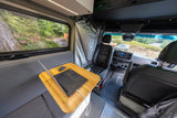 RV rental interior features a functional mobile office with a laptop, comfy bench, window view, and shower area.