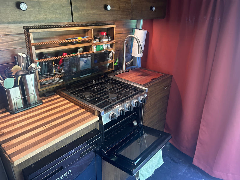 Enjoy this RV rental's compact kitchen with gas stove/oven, sink, wood counters, & smart storage for your adventures on the road. — photo 8