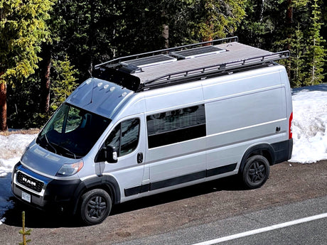 Adventure awaits in this silver Ram ProMaster camper van, ideal for RV rental and off-grid van life with solar power.