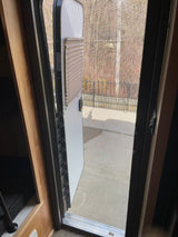 RV rental interior view through the partially open screen door, showing the outdoor area. Ideal for fresh air while camping.