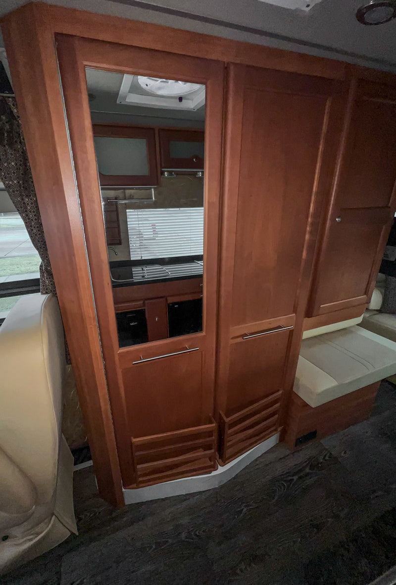 Spacious RV rental interior featuring a full kitchen with sink, cabinetry, window blinds, and dinette seating. Perfect for your next adventure. — photo 13