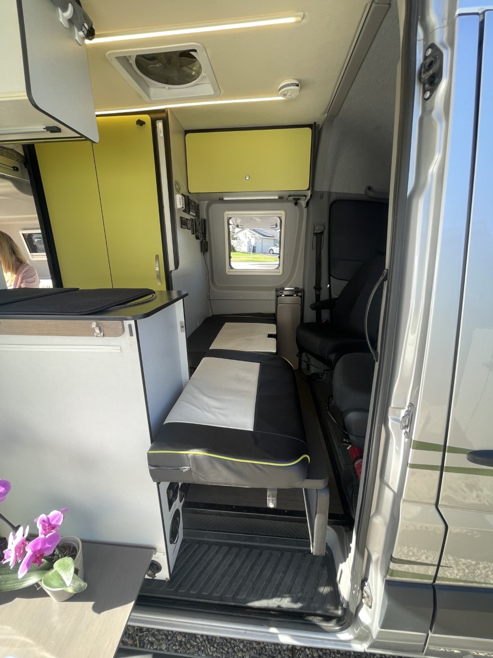Inside an RV rental: modern yellow cabinets, comfortable bench seating, and smart design for versatile mobile living. — photo 10