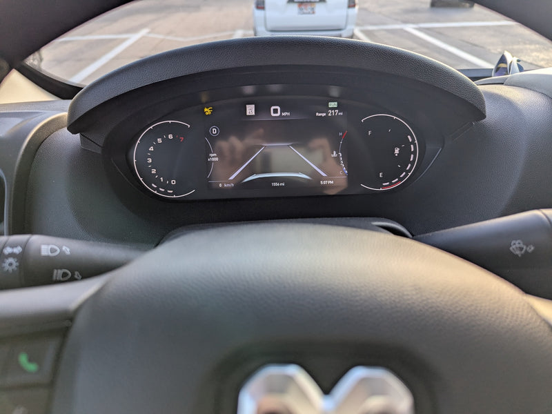 RV rental driving view: dashboard instrument cluster showing 0 MPH, 217-mile range, and 1556 total miles. — photo 12