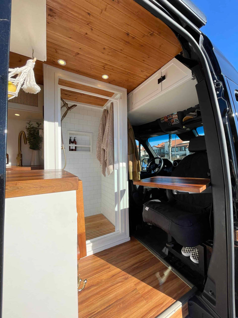  and a cozy dining area set for two.|Black RV rental van with bikes — photo 6