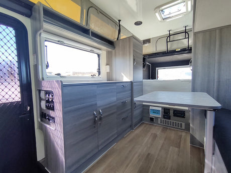 Spacious RV rental interior: a modern kitchen, dinette, and controls for a comfortable trip.