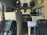 Step into this ModVans RV rental interior, featuring a kitchen, child seat, and smart storage for family travels.