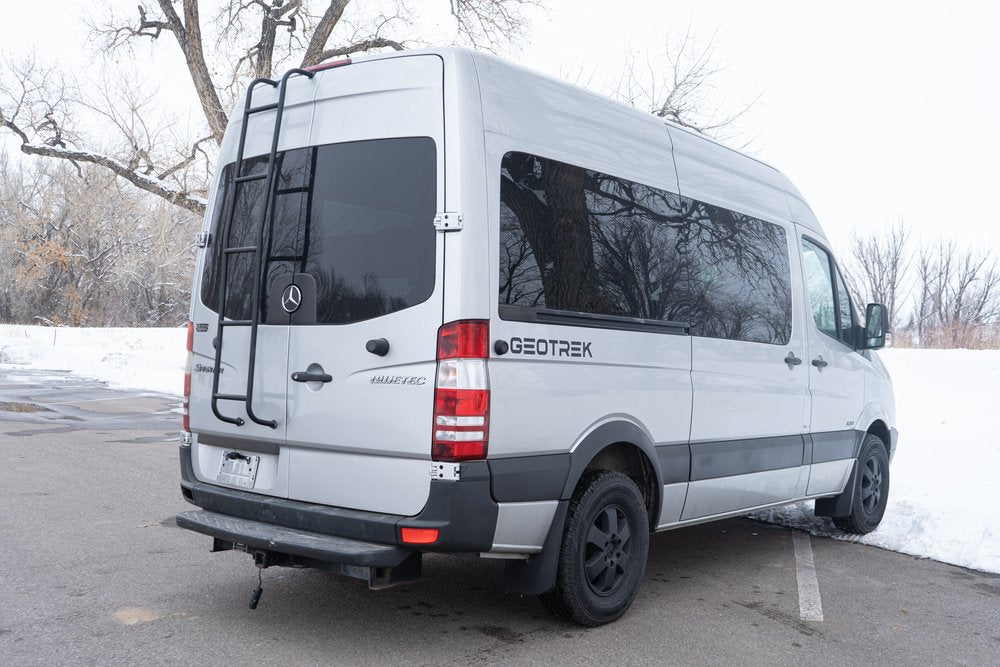 Silver Mercedes Sprinter Geotrek camper van, perfect for your next rv rental adventure. Features rear ladder & tinted windows.