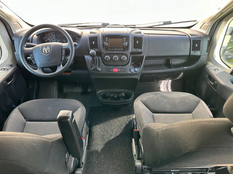 Explore an RV rental interior: Wide view of the spacious cockpit, dashboard, steering wheel, and front seats.