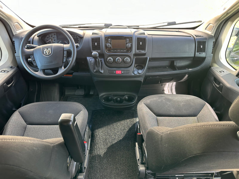 Explore an RV rental interior: Wide view of the spacious cockpit, dashboard, steering wheel, and front seats. — photo 13