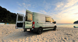 Experience beach adventures in this stylish RV rental van at sunset. Perfect for travel & outdoor living.