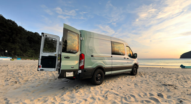 Experience beach adventures in this stylish RV rental van at sunset. Perfect for travel & outdoor living.