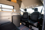 Spacious camper van interior featuring a kitchen with sink, fridge, and front cabin seats. Perfect for your next rv rental adventure.