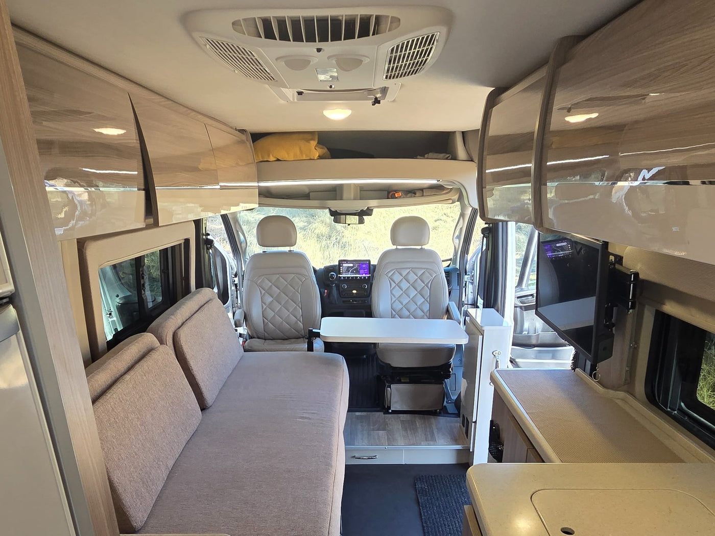  and a compact counter with integrated fridge.|Modern rv rental interior: compact kitchen — photo 11
