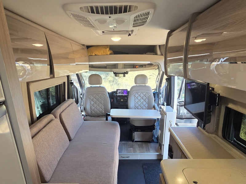  and a compact counter with integrated fridge.|Modern rv rental interior: compact kitchen — photo 11