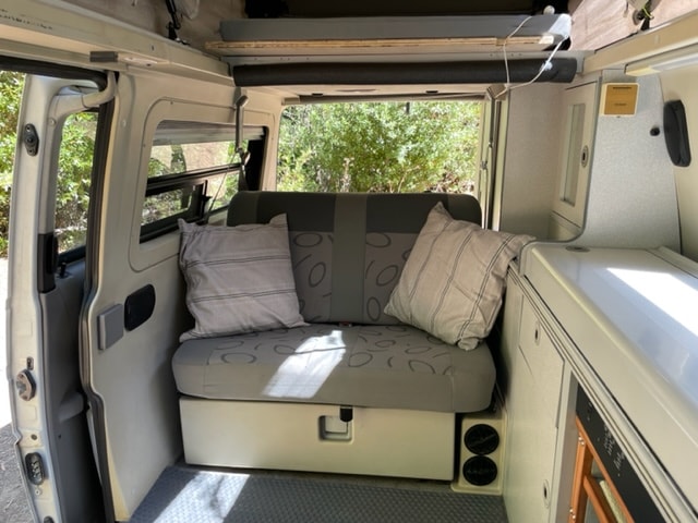  sunny campsite with a picnic table.|RV rental camper living space: compact kitchen with sink — photo 14