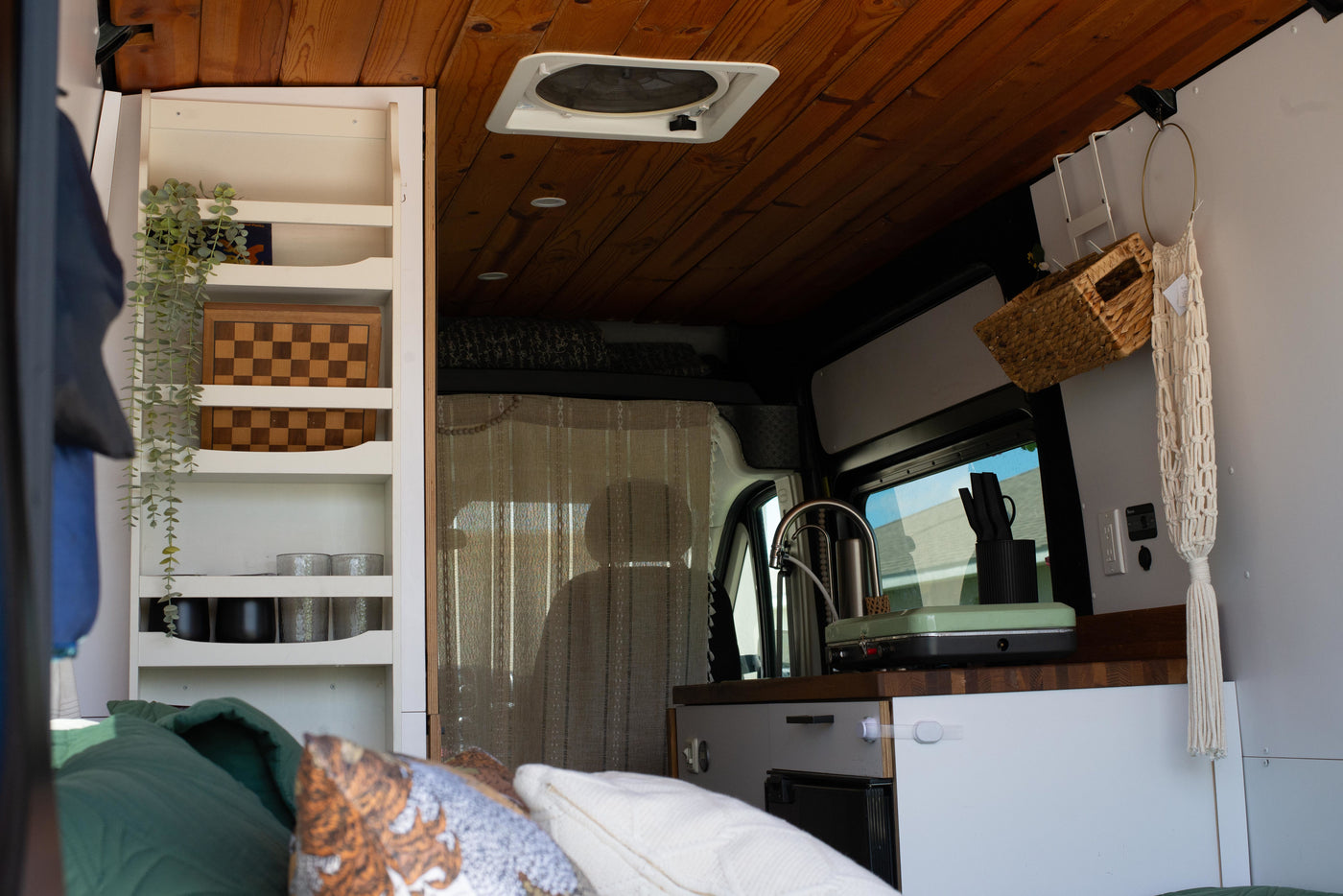 Step inside this RV rental! Cozy campervan living with a built-in kitchen, bed, and smart shelving for your adventures. — photo 7