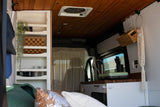 Step inside this RV rental! Cozy campervan living with a built-in kitchen, bed, and smart shelving for your adventures.