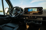 Modern RV rental driver's cabin: Steering wheel, navigation screen (San Diego map), and accessibility hand controls visible.
