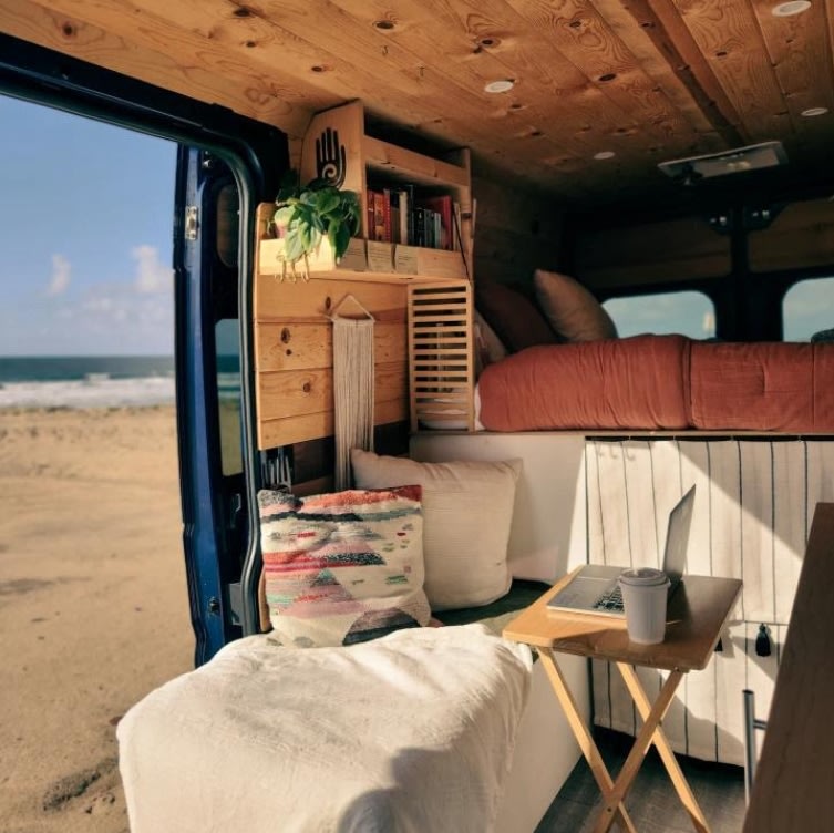  door open revealing interior. Sunset hues.|Cozy RV rental interior with ocean view from a camper van. Perfect for remote work & beach adventures.|Discover this charming rv rental: a cozy van conversion with a kitchen — photo 2