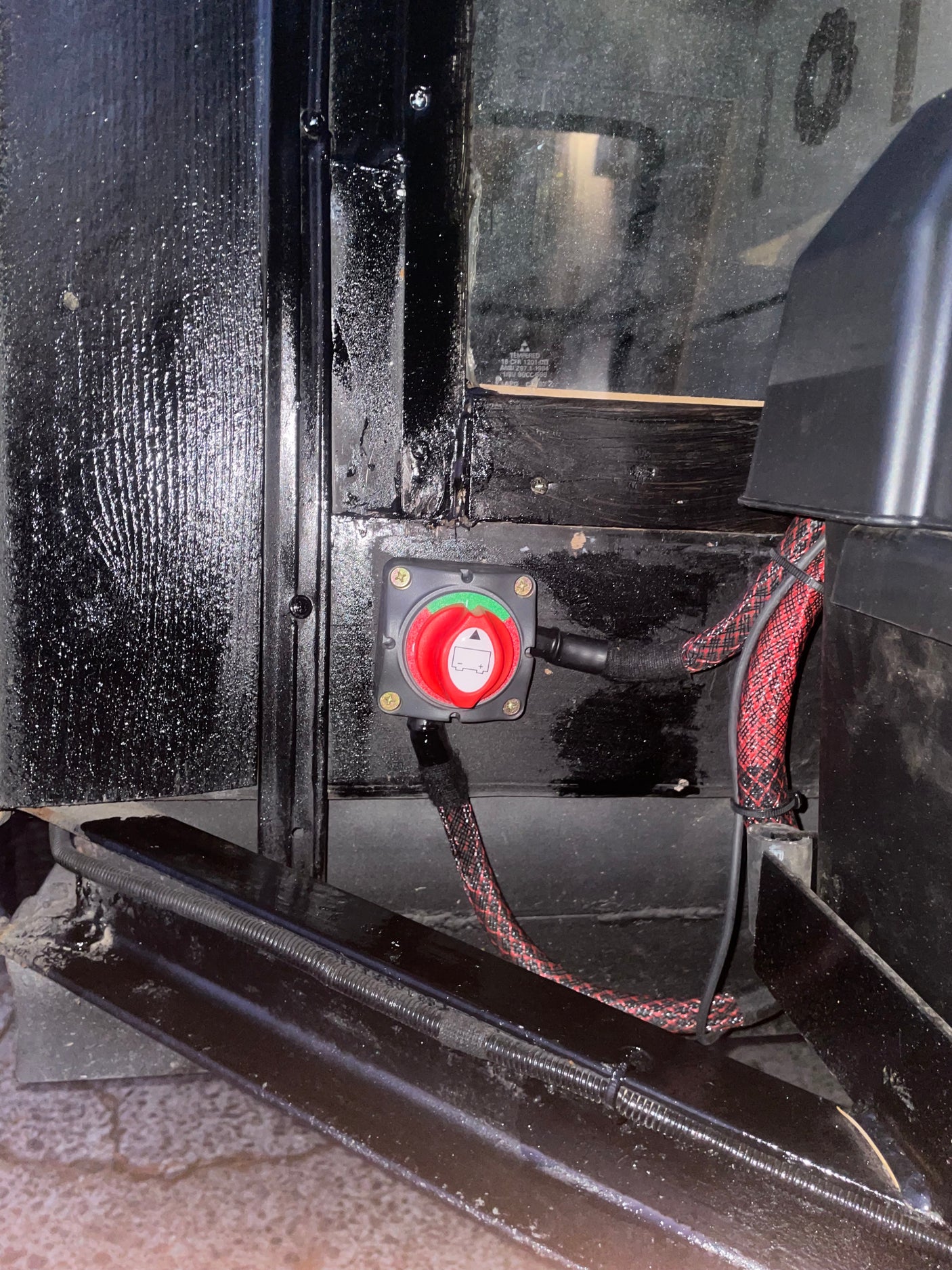 RV rental battery disconnect switch with red handle and braided cables, controls vehicle power for safety and storage.