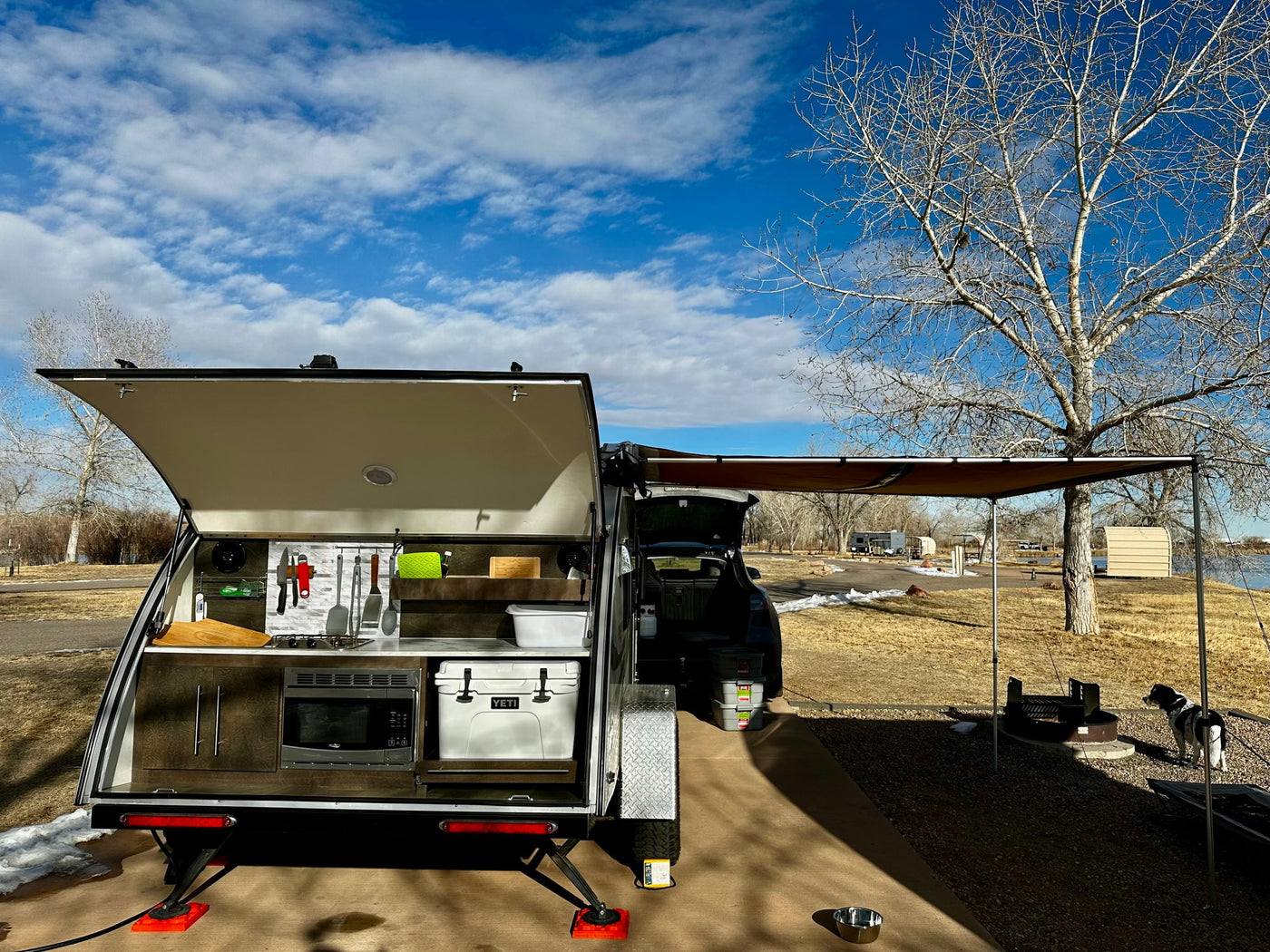  is parked at a snowy campsite under a blue sky
