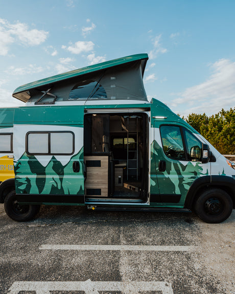 Green & white pop-top camper van with open side door. Ready for adventure with this spacious RV rental.