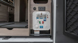 RV rental's interior utility panel: water hookups, electrical outlet, and winterizing instructions visible. Essential for mobile living.