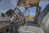 Driver's perspective inside an RV rental van, highlighting the steering wheel, dashboard, and black leather seats.