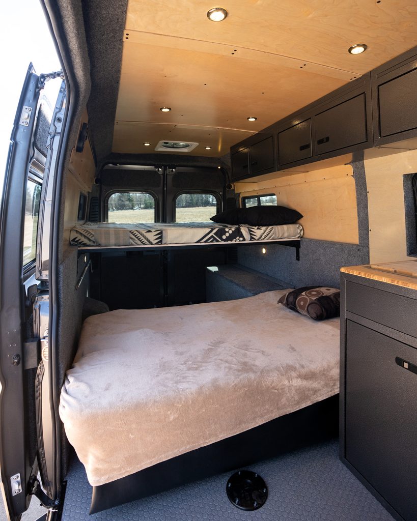  and compact kitchen.|Spacious camper van interior with elevated bed — photo 4