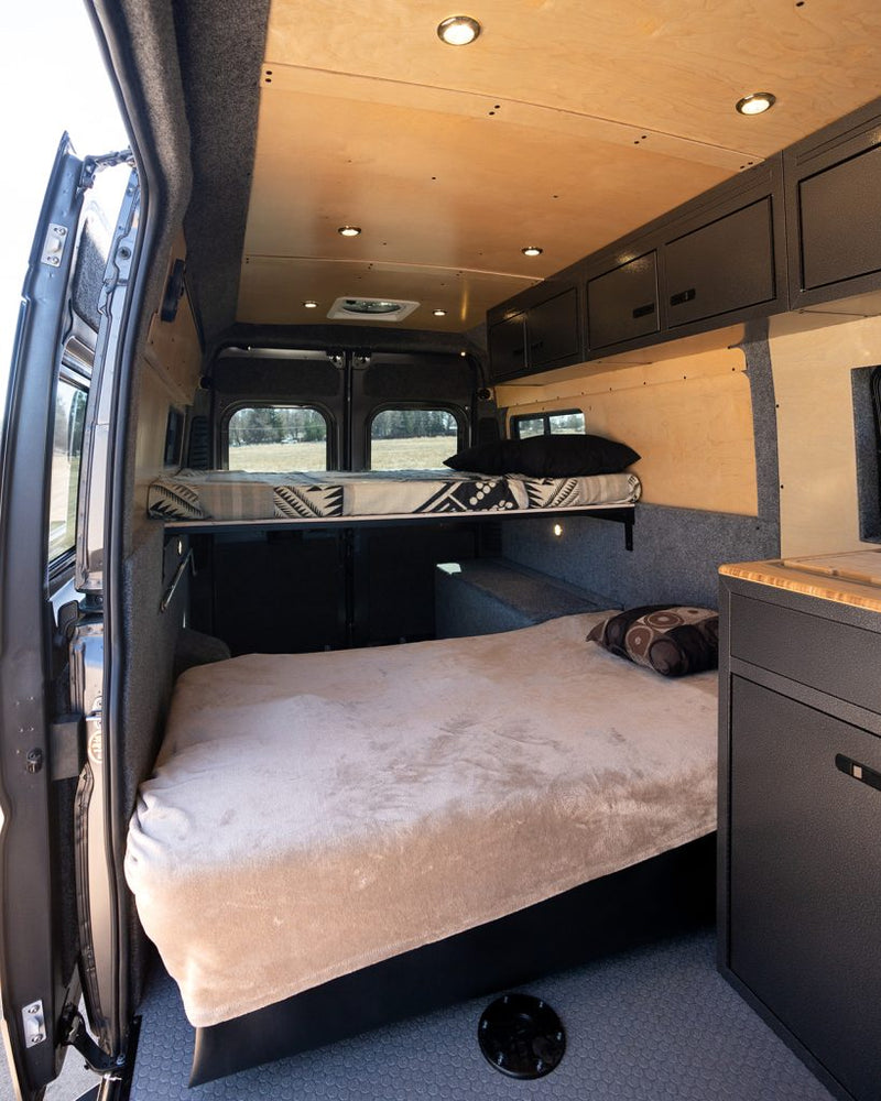  and compact kitchen.|Spacious camper van interior with elevated bed — photo 4